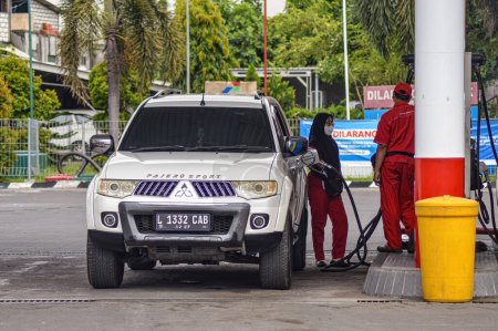 Foto de Un Mitsubishi Pajero blanco se está llenando de gasolina bio-diesel en una gasolinera Pertamina, Indonesia, 16 de enero de 2024. - Imagen libre de derechos