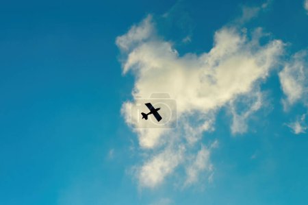 Téléchargez les photos : Un avion télécommandé de modélisation aérienne sur fond de ciel bleu nuageux. parfait pour le fond, la texture et le contenu aéronautique - en image libre de droit
