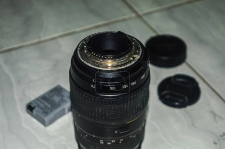 a black telephoto lens with camera equipment in the background. perfect for photography content.