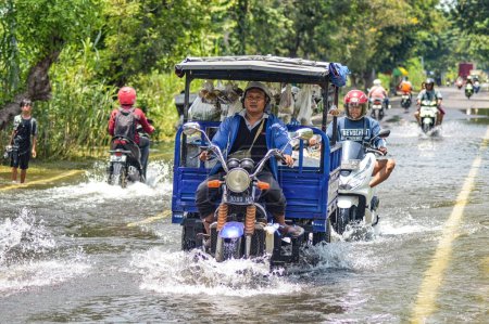 Téléchargez les photos : Plusieurs véhicules tels que des camions, des bicyclettes et des voitures ont été piégés par les eaux de crue à Gresik Regency, Indonésie, 21 février 2024. - en image libre de droit