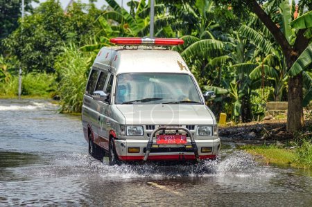 Photo for An ambulance passing through flood waters in Gresik Regency, Indonesia, 21 February 2024. - Royalty Free Image