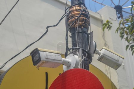 A CCTV surveillance camera attached to an electricity pole is monitoring the city