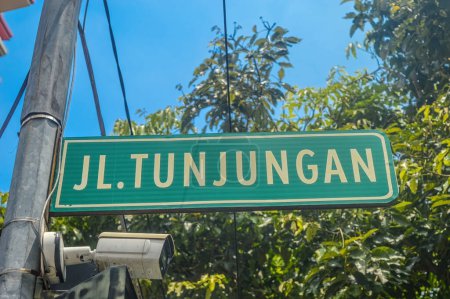 a Tunjungan road sign with a CCTV camera at the bottom