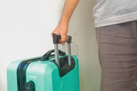 Téléchargez les photos : Homme mûr tirant une valise verte turquoise - en image libre de droit