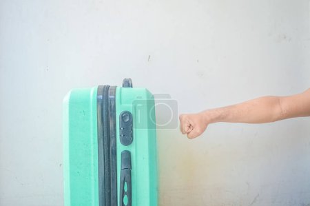 Téléchargez les photos : Main frappant la valise verte turquoise - en image libre de droit