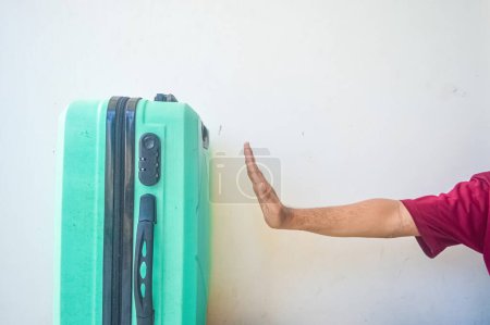 hand stops the turquoise green suitcase