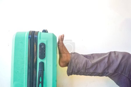 Téléchargez les photos : Pieds ont donné un coup de pied dans la valise verte turquoise - en image libre de droit