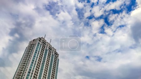 a high rise building apartment with cloudy sky copy space