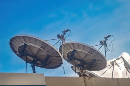 two large parabolic antennas on the roof with blue sky background