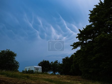 Photo for Before a storm mammatus clouds are gathering over a camper trees field in a supercell - Royalty Free Image