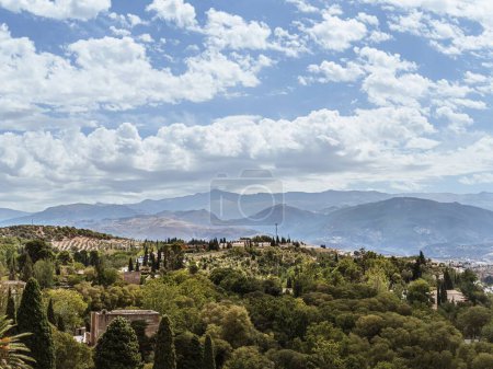 View of the Palace Gardens and the Sierra Nevada mountain range in Granada, Andalusia, Spain, summer vacation travel destination, panoramic view