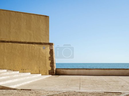 Foto de Barcos anclados y personas tomando el sol en una playa de arena de verano Playa de La Caleta en Cádiz, Andalucía, España, espacio para copiar - Imagen libre de derechos