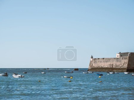 Foto de Barcos anclados junto a las murallas del fuerte de Santa Catalina en Cádiz, Andalucía, España - Imagen libre de derechos