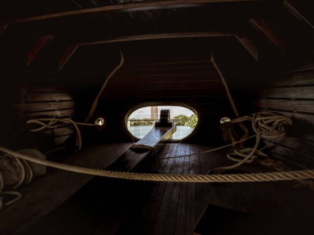 Interior of the stern area with the rudder for steering in the wooden replica carrack historical ship Nao Victoria of Magellan in Seville, Spain