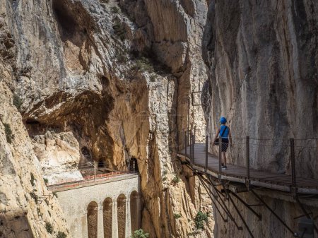 A young female woman girl tourist walking on the walkway at the gorge canyon of the El Caminito del Rey in Andalusia, Malaga, Spain