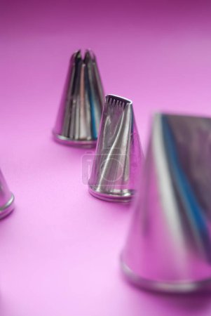 Photo for Baking tools, variety of piping tips on a pink background - Royalty Free Image