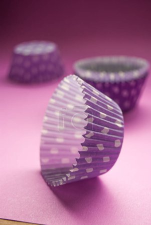 Photo for Close up of colorful polka dot cupcake liners, baking accessories, on pink background - Royalty Free Image