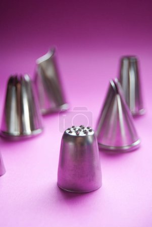 Foto de Baker consejos de tuberías sobre un fondo rosa, boquillas, decoración de pasteles, metálico, herramientas de hornear de acero inoxidable, primer plano - Imagen libre de derechos