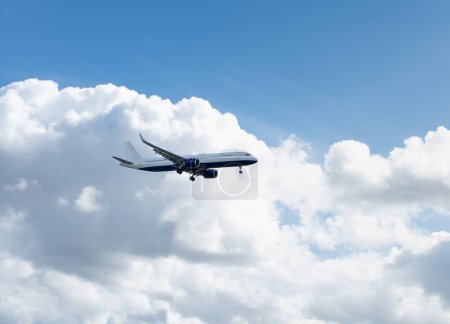 Photo for Passenger plane flies in the sky against a blue sky with clouds. Travel by air - Royalty Free Image