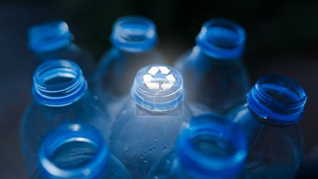 Nahaufnahme des Mundes einer Trinkwasserflasche aus Kunststoff mit einem prominenten weißen Recycling-Symbol in der Mitte. Recycling-Müllkonzept. Selektiver Fokus.