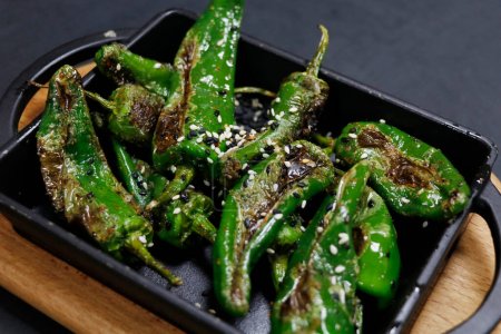 blistered padron chili peppers, bar, pub bite food in close up with black background