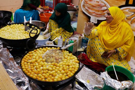 Foto de Dubái, Emiratos Árabes Unidos - 25 de abril de 2023 Preparación Logma o Lugaimat (Legaimat), uno de los dulces emiratos árabes más populares en Emiratos Árabes Unidos, servido con jarabe de dátiles o miel - Imagen libre de derechos