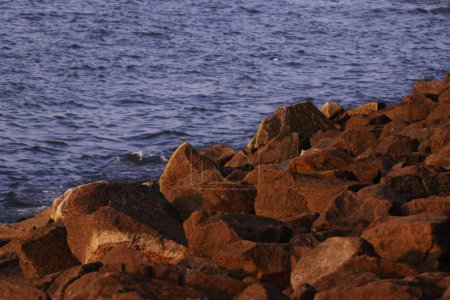 Foto de Barrera y presa de roca, protección de agua de mar y olas en el estuario, piedras para proteger la orilla de las olas del mar
 . - Imagen libre de derechos