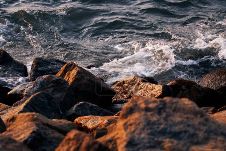 Foto de Barrera y presa de roca, protección de agua de mar y olas en el estuario, piedras para proteger la orilla de las olas del mar
 . - Imagen libre de derechos