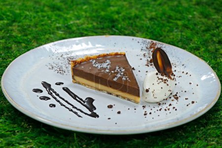 salted caramel tart with whipped cream with green background