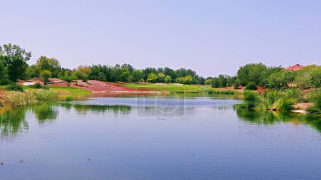 Photo for Beautiful golf course near the lake in a sunny day - Royalty Free Image