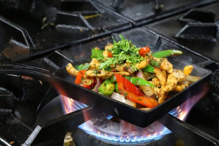 Photo for Mexican chicken fajitas on sizzling plate - Royalty Free Image
