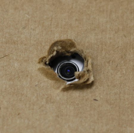 Téléchargez les photos : Caméra espion cachée fixée derrière le carton ou le toit - en image libre de droit