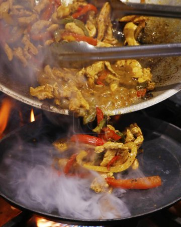 Photo for Mexican authentic food, chicken fajitas served on a hot smoking sizzling plate - Royalty Free Image