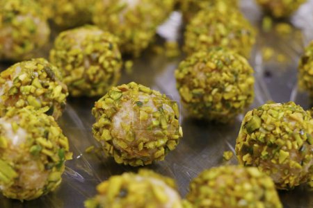 protein balls rolled in sliced pistachio nuts, called as energy balls