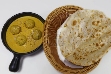 Foto de Paneer pasanda (requesón) comida india en salsa rica de anacardo y azafrán, servida con naan tandoori - Imagen libre de derechos