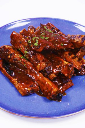 Photo for Barbeque sauce glazed baby pork ribs in a plate with white background - Royalty Free Image