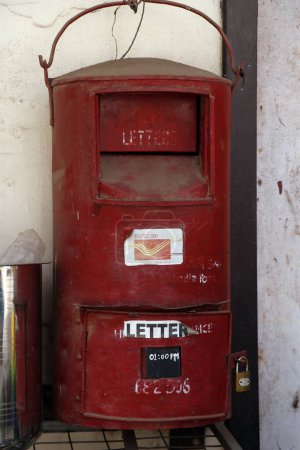 Photo for An old Indian red  post box hanging on a wall in kerala - Royalty Free Image