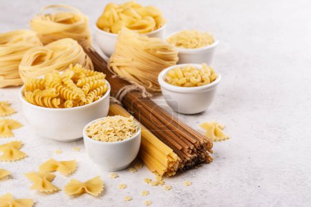 Photo for Pasta month. Assortment of uncooked pasta and noodles. Italian food culinary concept. Collection of different raw pasta on cooking table - Royalty Free Image