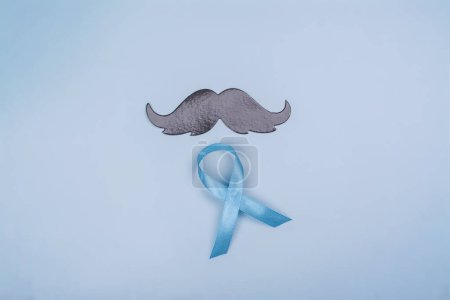 Foto de El bigote negro y la cinta azul - el símbolo de la salud de los hombres, la prevención del suicidio. Salud mental. Mes de concienciación sobre el cáncer testicular o de próstata - Imagen libre de derechos