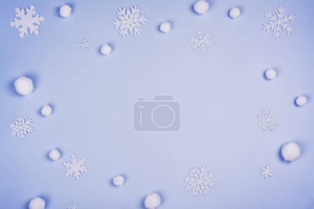 Téléchargez les photos : Fond de Noël avec des flocons de neige blancs et des décorations argentées de vacances sur bleu. Espace de copie. Vue du dessus - en image libre de droit