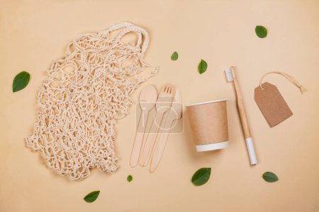 Photo for Mesh bag, paper cups, bamboo tooth brush and wooden utensils. Eco natural background, zero waste concept. Stop plastic pollution. Top view - Royalty Free Image