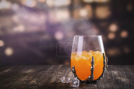 Téléchargez les photos : Halloween cocktail orange dans des squelettes effrayants lunettes à main - en image libre de droit