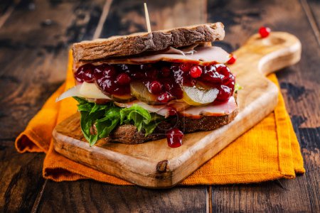 Photo for Homemade leftover thanksgiving day sandwich with turkey, cranberry sauce and vegetables. Dark rustic style - Royalty Free Image