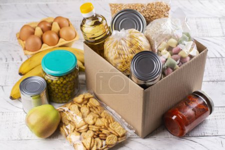 Photo for Food donation box. Pasta, cereals, various canned food in a carboard box. National food bank day or food delivery background - Royalty Free Image