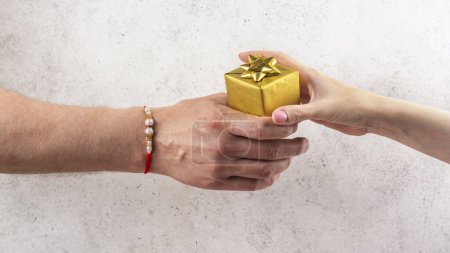 Téléchargez les photos : Happy Raksha Bandhan Fond de vacances. frère indien portant rakhi bracelet donne boîte cadeau à sa sœur. - en image libre de droit