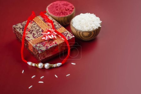 Téléchargez les photos : Raksha Bandhan fond. Coffret cadeau riz, kumkum et bracelet rakhi. Festival traditionnel indien des fêtes Raksha Bandhan - en image libre de droit
