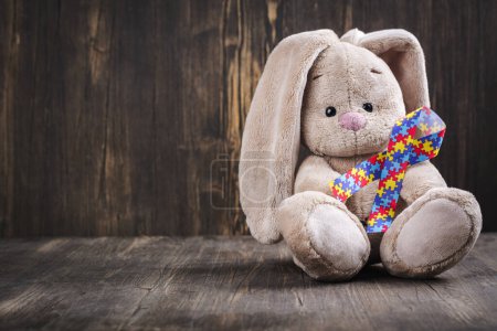 Photo for Autistic pride day - 18 june. World autism awareness day or month background. Cute rabbit toy with jigsaw ribbon in paws Copy space - Royalty Free Image