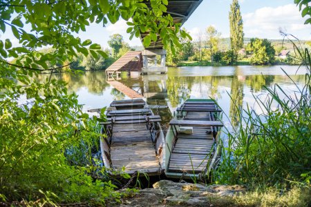 Téléchargez les photos : Belle vue sur la rivière Berounka et les bateaux en bois qui se dressent sous le pont, la forêt et les montagnes, République tchèque. Photo de haute qualité - en image libre de droit