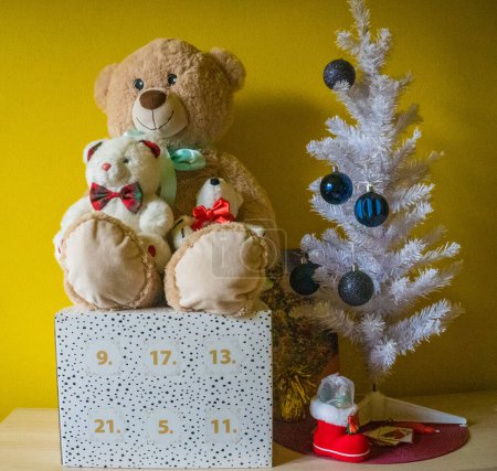 Foto de Arreglo de Navidad, decoraciones colgantes aisladas sobre fondo amarillo. Regalos bajo el árbol de Navidad, dulces, osos y calendario de adviento. Foto de alta calidad - Imagen libre de derechos