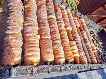 Process of baking trdelnik in Prague, Grilled rolled dough topped with Cinnamon sugar, The food is about vegag, lean. Traditional Czech hot sweet pastry, street bakery in Prague. High quality photo